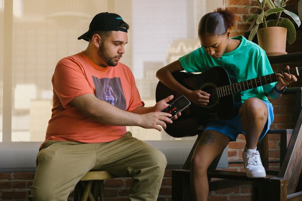 Two people playing guitar together